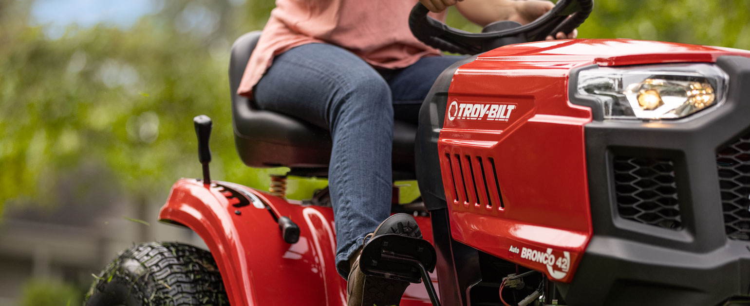 woman mowing lawn with a riding mower