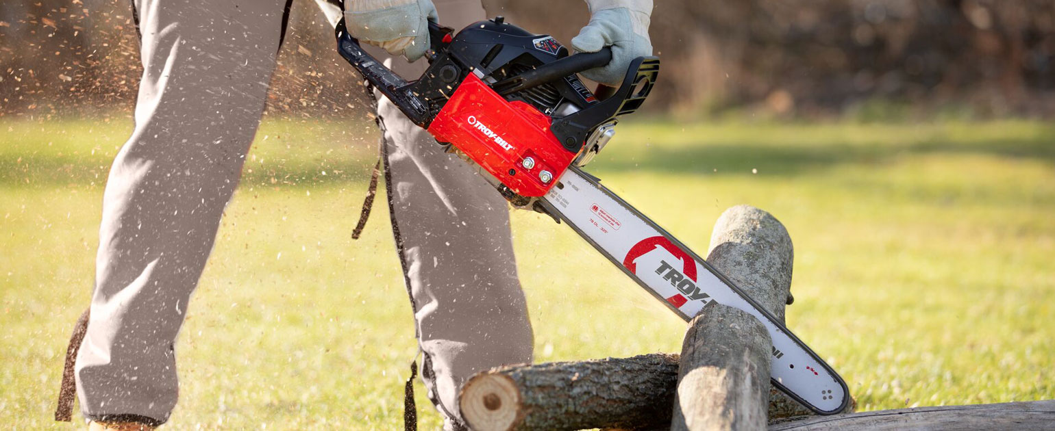 man cutting through a tree branch